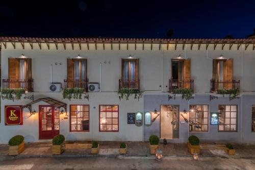 a white building with windows and doors at night at Kastalia Boutique Hotel in Delfoi