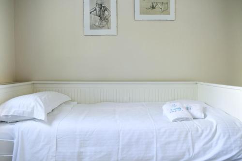 a white bed with two pillows on top of it at Serenity Luxury Villa, Skiathos in Agia Paraskevi