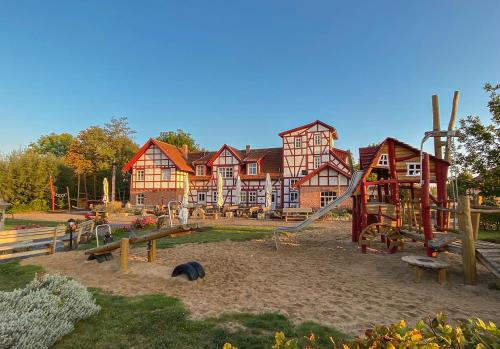 a playground in front of a large building at Hotel Restaurant Mühlenhof Bosse in Dachwig