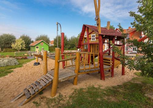 a playground with a bench and a house at Hotel Restaurant Mühlenhof Bosse in Dachwig