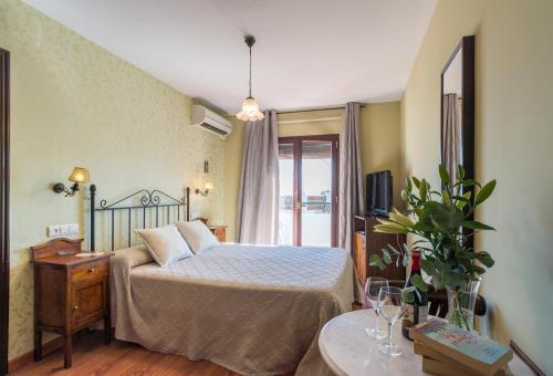 1 dormitorio con 1 cama, TV y mesa en Hostal El Escudo de Mijas, en Mijas