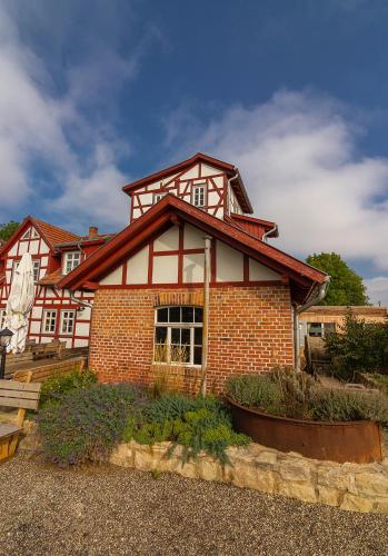 a large brick house with a red at Hotel Restaurant Mühlenhof Bosse in Dachwig