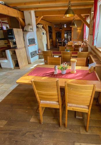 a wooden table with chairs and a red table cloth at Hotel Restaurant Mühlenhof Bosse in Dachwig