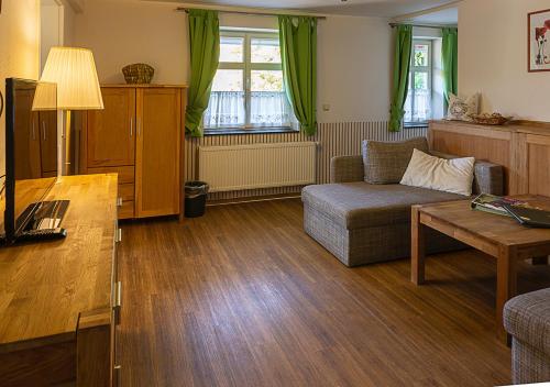 a living room with a couch and a table at Hotel Restaurant Mühlenhof Bosse in Dachwig