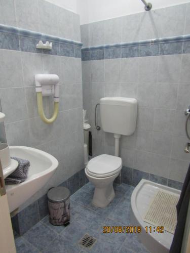uma casa de banho com um WC, um lavatório e uma banheira em ALKMENE STUDIOS em Skiathos