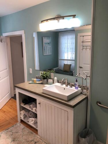 uma casa de banho com um lavatório e um espelho grande em Stamford Gables Bed and Breakfast em Stamford