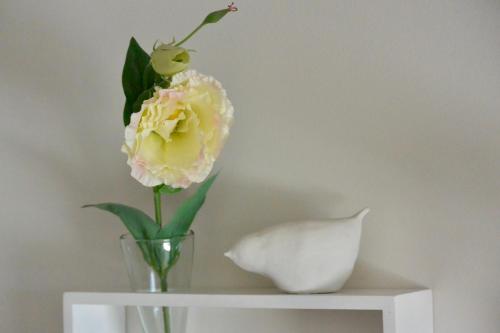 a vase with a flower in it on a shelf at Chambres d'Hôtes Coteaux Sud in Jurançon