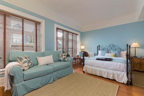 Dormitorio azul con cama y sofá en Les Immeubles Charlevoix - Le Perchoir 1020, en Quebec