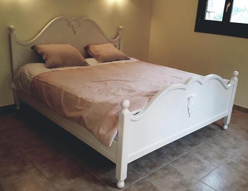 ein weißes Bett mit Kissen darauf im Schlafzimmer in der Unterkunft Villa Lavendel in Montauroux
