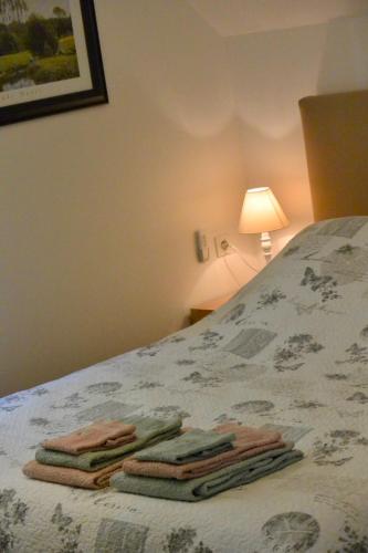 a bedroom with a bed with three towels on it at Chambres d'Hôtes Coteaux Sud in Jurançon