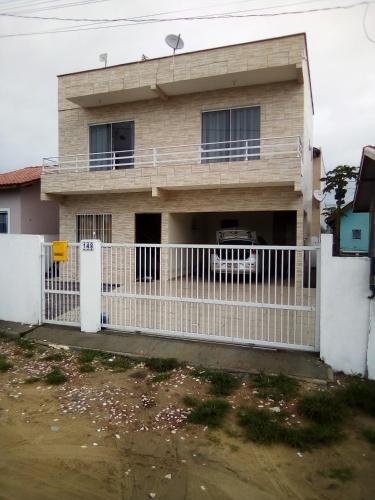 a house with a white fence in front of it at Casa no rio vermelho in Florianópolis