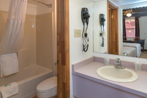 a bathroom with a sink and a toilet and a phone at Thunderbird Lodge in Chinle