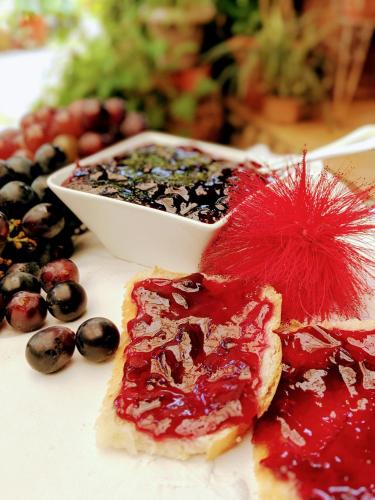 a plate of food with berries and a bowl of jam at Tranquil Resort - Blusalzz Collection, Wayanad - Kerala in Ambalavayal