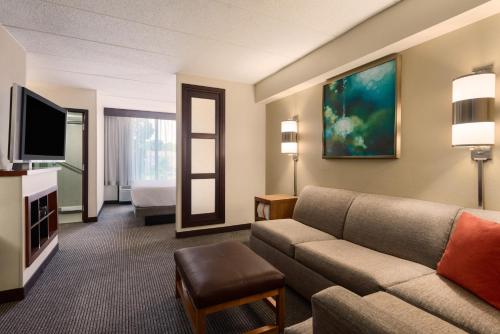 オーウィングス・ミルズにあるHyatt Place Baltimore Owings Millsのソファとテレビがあるホテルの部屋