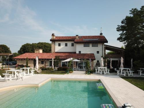 une maison avec une piscine en face d'une maison dans l'établissement B&B La Corte Dei Vizi, à Clauiano