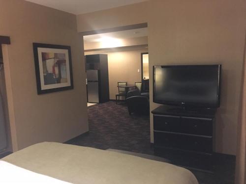 a hotel room with a bed and a flat screen tv at Best Western PLUS Fox Creek in Fox Creek
