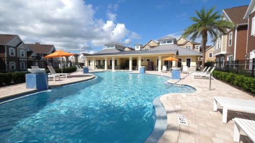 a swimming pool with chairs and a house at Summerville Vacation Resort in Orlando