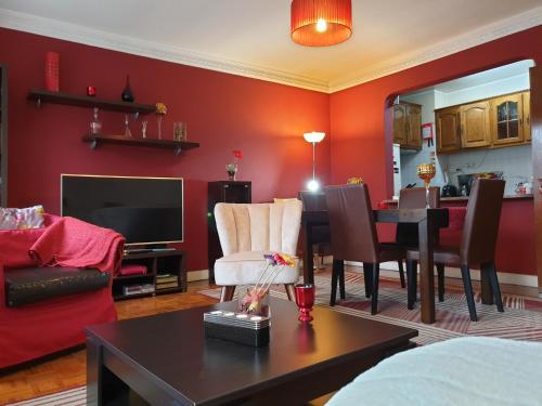 a living room with red walls and a dining room at Historic Oporto Apartment at oporto UNESCO area, in front of Porto Wine caves in Porto