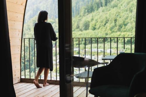 a woman standing on a balcony looking out the window at Himmelchalet - Alpencamping Nenzing in Nenzing