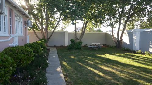 a backyard with a bench and trees and a fence at The Fancy Cactus in Colesberg