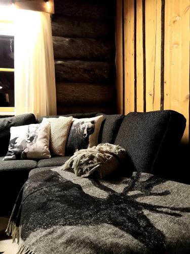a couch with a blanket on it in a living room at Lapland Lodge Pyhä Ski in, sauna, free WiFi, national park - Lapland Villas in Pyhätunturi