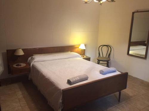 1 dormitorio con cama, espejo y silla en CASA NONI en Salta