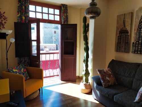 a living room with a couch and a sliding glass door at Apartamento La Peatonal in San Sebastián de la Gomera