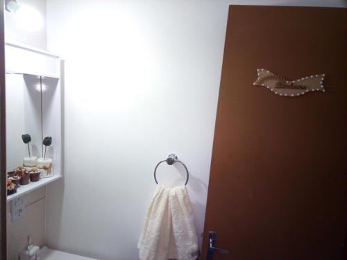 a white dress hanging on a door in a bathroom at Aptos Farroupilha in Farroupilha