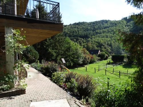 a brick walkway leading to a garden with a hill at Relais des Eveux in La Roche-en-Ardenne