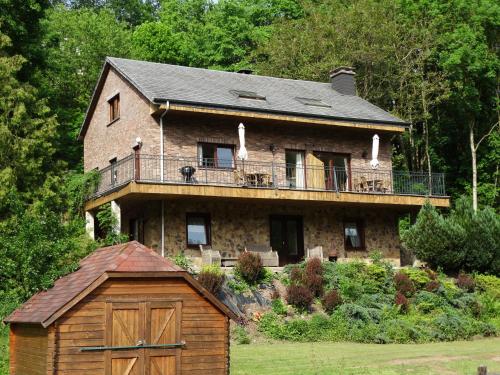 a large brick house with a balcony on top of it at Relais des Eveux in La Roche-en-Ardenne