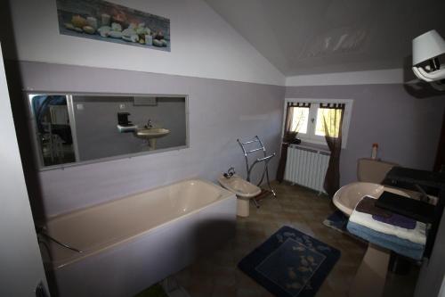 une salle de bain avec une baignoire, des toilettes et un lavabo dans l'établissement la Chaumine aux étoiles, à Camurac
