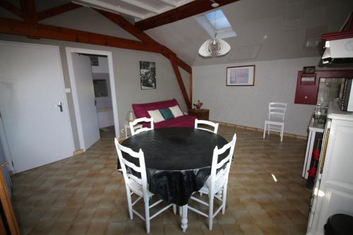 une cuisine et une salle à manger avec une table et des chaises dans l'établissement la Chaumine aux étoiles, à Camurac