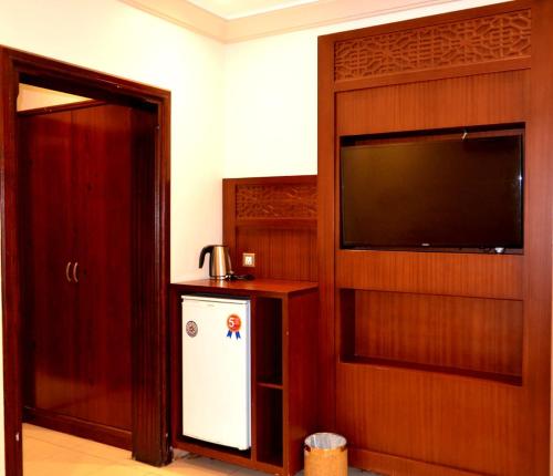 a living room with a television and a refrigerator at سفير جدة للشقق المخدومة in Jeddah