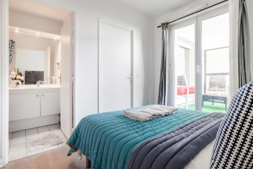 une chambre avec un lit et une grande fenêtre dans l'établissement Appartement spacieux avec terrasse près de Paris et du Stade de France, à Saint-Denis