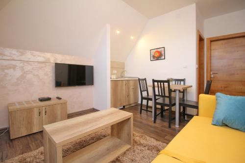 a living room with a yellow couch and a table at All Seasons Residence in Zlatibor