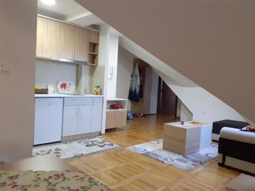 eine Küche und ein Wohnzimmer mit einer Treppe in der Unterkunft Apartman zlatibor in Zlatibor
