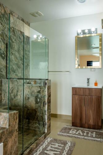 a bathroom with a glass shower and a sink at Lake Arenal Condos in Naranjos Agrios
