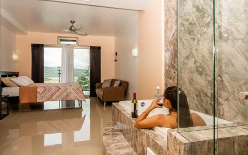 a woman in a bath tub talking on a cell phone at Lake Arenal Condos in Naranjos Agrios
