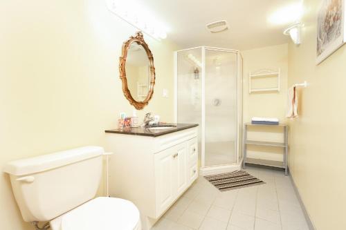 a white bathroom with a toilet and a shower at Lily's garden in Charlottetown