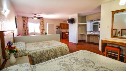 un soggiorno con due letti e una cucina di HOTEL & SUITES MARROD a Chihuahua