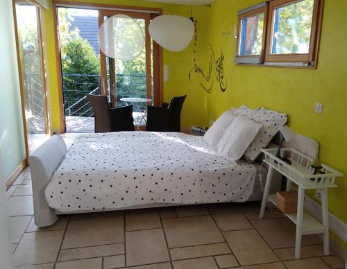 een slaapkamer met een bed en een tafel en ramen bij A l Ombre des Catalpas in Bischwihr