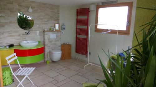 een badkamer met een wastafel, een toilet en een raam bij A l Ombre des Catalpas in Bischwihr