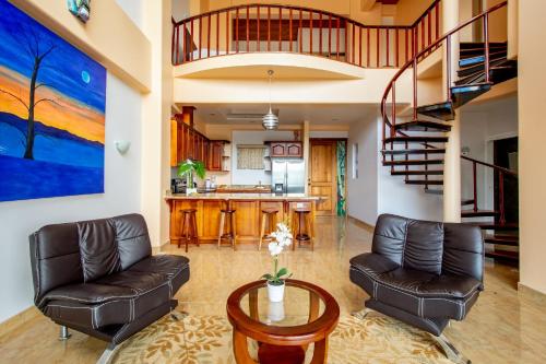 a living room with two leather chairs and a table at Lake Arenal Condos in Naranjos Agrios