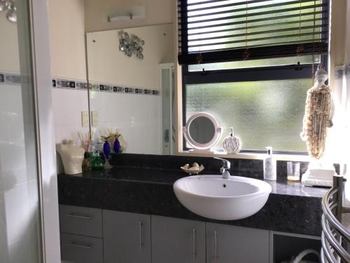 a bathroom with a white sink and a window at The Gallery in Taupo