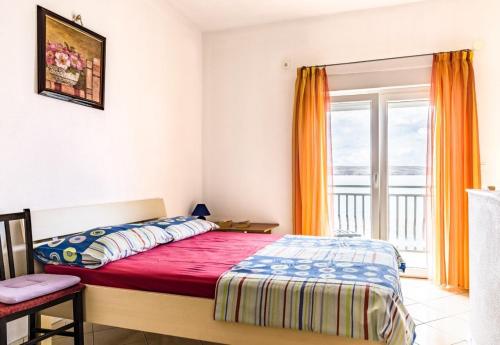 een slaapkamer met een bed en een raam bij Apartments Domagoj - on the beach in Lukovo Šugarje