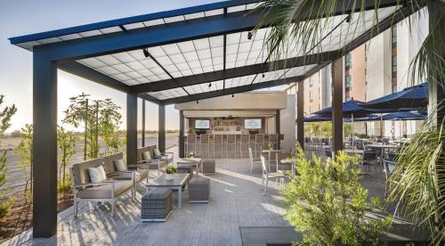 a patio with chairs and tables and umbrellas at Ayres Hotel San Diego South - Chula Vista in Chula Vista