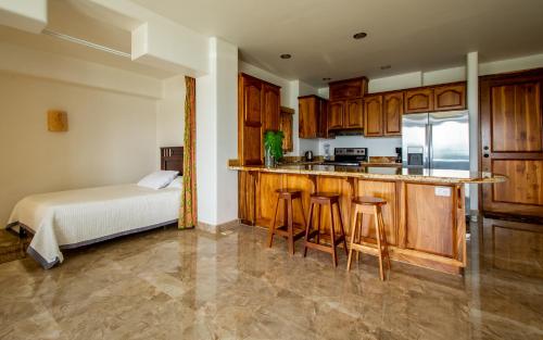 a kitchen with a bed and a kitchen with wooden cabinets at Lake Arenal Condos in Naranjos Agrios
