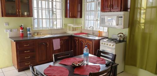Unit 4 Private Apartment - Roseau في روسو: مطبخ مع طاولة عليها زجاجة ماء