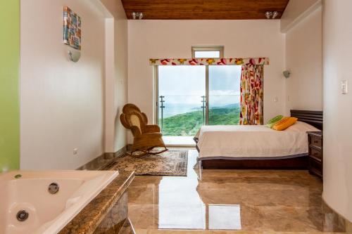 a bedroom with a bed and a tub and a window at Lake Arenal Condos in Naranjos Agrios