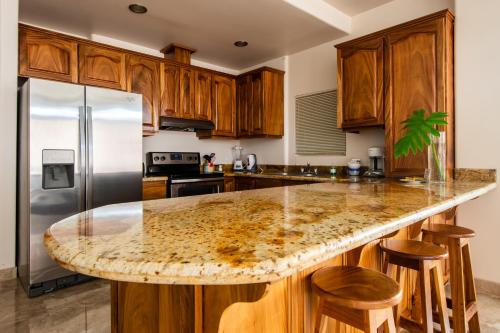 a kitchen with a granite counter top and wooden cabinets at Lake Arenal Condos in Naranjos Agrios